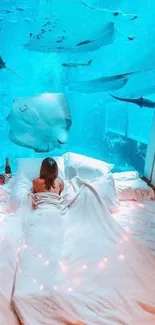 Person lounging in a cozy bed with an underwater view.