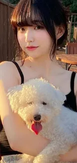 Young woman sitting outdoors with a white fluffy dog in cozy evening light.