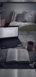 Laptop, open book, and coffee on bed creating a cozy study nook.