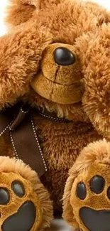 Adorable brown teddy bear plush toy covering eyes.