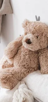 A cozy teddy bear rests in a soft, beige-toned room.