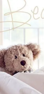 Teddy bear nestled in soft white bedding, perfect cozy wallpaper.