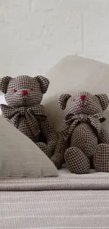 Two fabric teddy bears on a cozy bed.