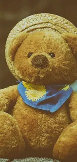 Teddy bear with straw hat and blue scarf.