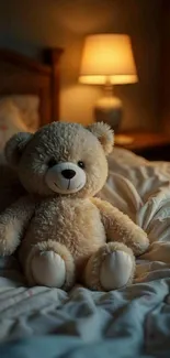 A teddy bear sits on a cozy, softly lit bed at night.