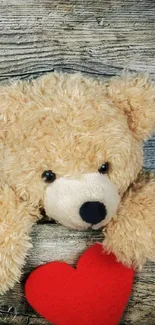 Teddy bear with red heart on rustic wooden background.