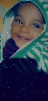 A smiling baby in a green striped hoodie with a starry background.