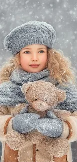 Child in winter attire holding a teddy bear with snowfall background.