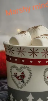 Festive mug with marshmallows and red accents on a patterned background.