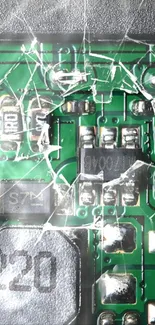 Close-up of a cracked green circuit board with intricate electronic details.