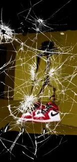 Bold red sneakers behind cracked glass for a modern abstract art wallpaper.