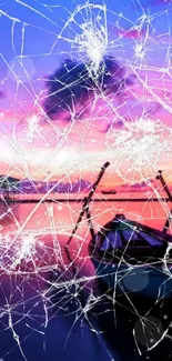 Sunset boat view through cracked glass with pink and purple sky.