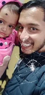 Cracked screen effect over a smiling person with child in pink.