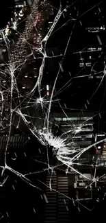 Cracked glass over a city night view creates a dramatic urban aesthetic.