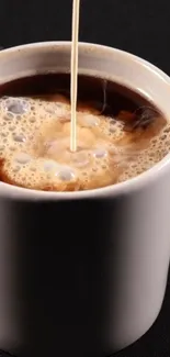 Creamy swirls in a cup of black coffee.