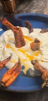 Rustic dish with yogurt and peppers on a blue plate.