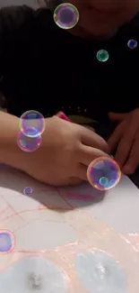 Child drawing with colorful bubbles overlay on paper.