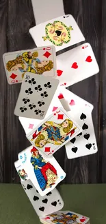 Dynamic cascade of playing cards on wooden background mobile wallpaper.