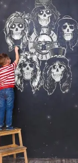 Child drawing skull designs on a black chalkboard wall.