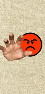 Hand reaching for angry emoji on beige background wallpaper.