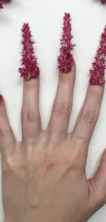 Creative floral hand art with magenta petals on fingers.