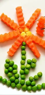 Vegetable art flower made from carrots and peas on a white plate.