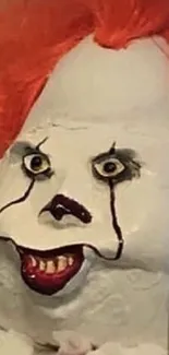 Creepy clown with orange hair and intense expression in horror-themed wallpaper.