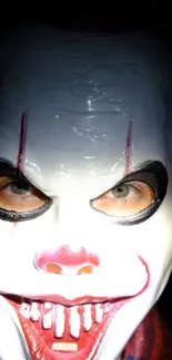 Close-up of eerie clown face in darkness.