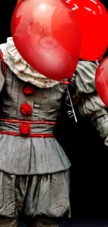 Clown in gray costume holding red balloons.