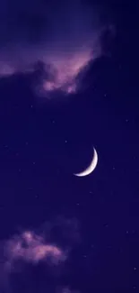 Crescent moon in a starry indigo night sky with purple clouds.