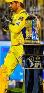 Cricket player in yellow with IPL trophy.