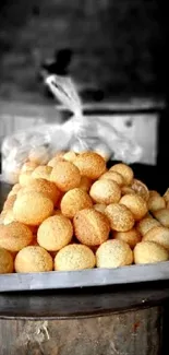 A stack of golden pani puri on a dark background.