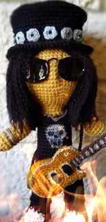 Crochet doll with sunglasses and guitar in beige background.