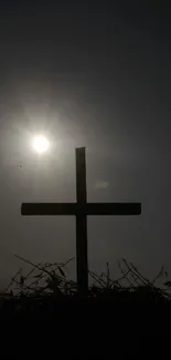 Silhouette of a cross against a sunset.