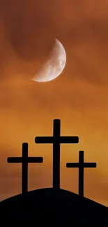 Three crosses silhouetted against an orange sky with a crescent moon.