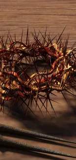 Crown of thorns with nails on wood texture background.