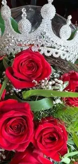 A silver crown adorned on a bouquet of vibrant red roses.