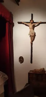 Mobile wallpaper of a crucifix on a wall in a dimly lit room.