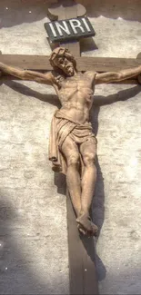 Artistic wooden crucifix on a textured wall.