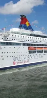 Vibrant cruise ship sailing under clear blue sky.