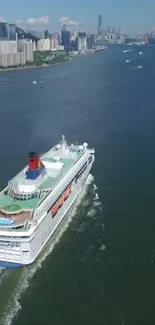 Aerial view of cruise ship sailing through a city harbor with skyscrapers.