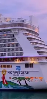 Norwegian cruise liner at sunset with serene ocean backdrop.