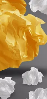 Yellow and white crumpled paper on gray background, artistic wallpaper.