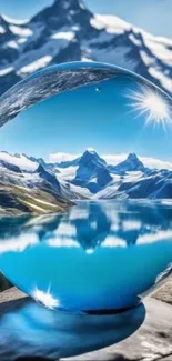 Crystal ball reflecting a snowy mountain landscape under a clear blue sky.