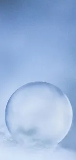 Crystal ball on icy surface with blue background.