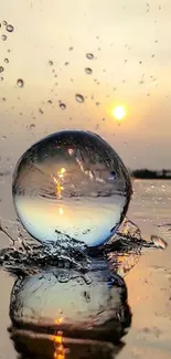 Crystal ball on water with sunset reflection and splashes.