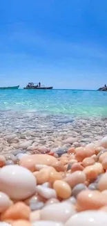 Beach with turquoise water and pebbles under a clear blue sky.