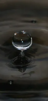 Close-up of water droplet on dark surface, showcasing clarity and motion.