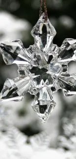 Crystal snowflake hanging against a snowy background, reflecting winter beauty.