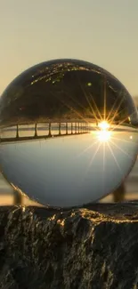 Crystal sphere reflecting beach sunset with sun's rays shining through.